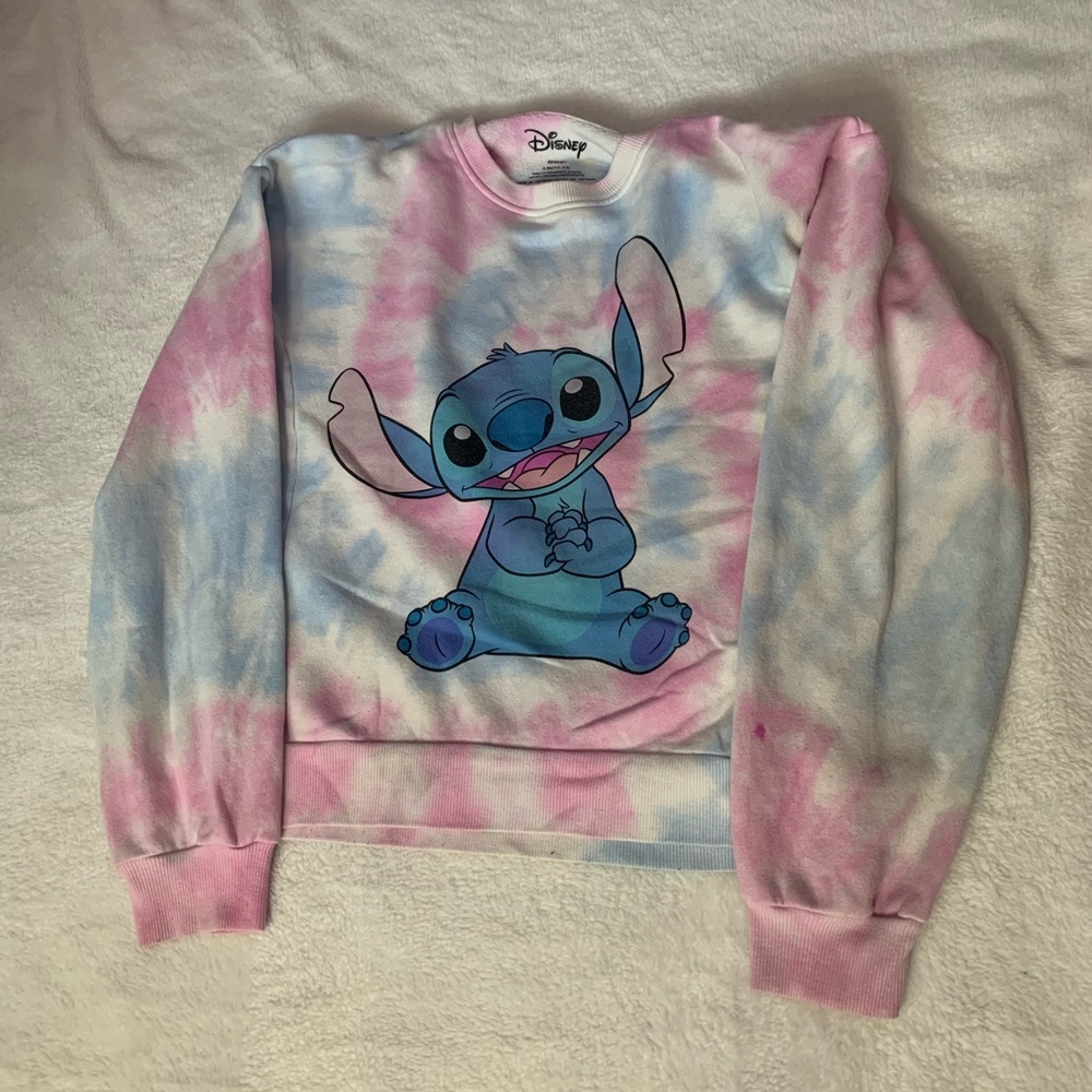 Worn, tie-dye sweater with Stitch on the front